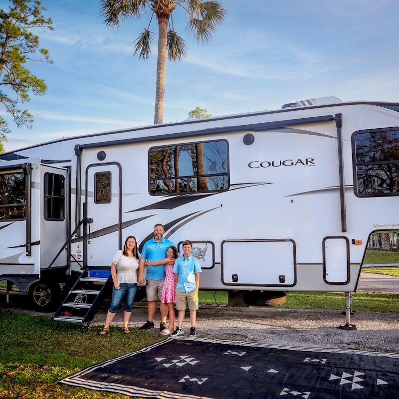 Kaylee and Steve Techau with their family in front of their Keystone Cougar RV