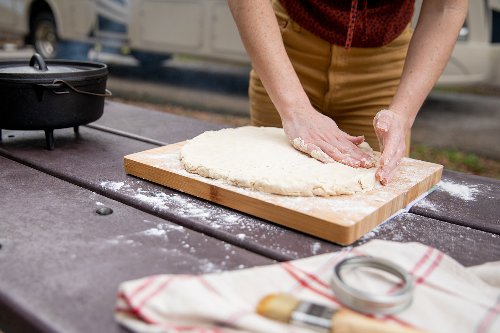 Patting biscuit dough into a uniform thickness.