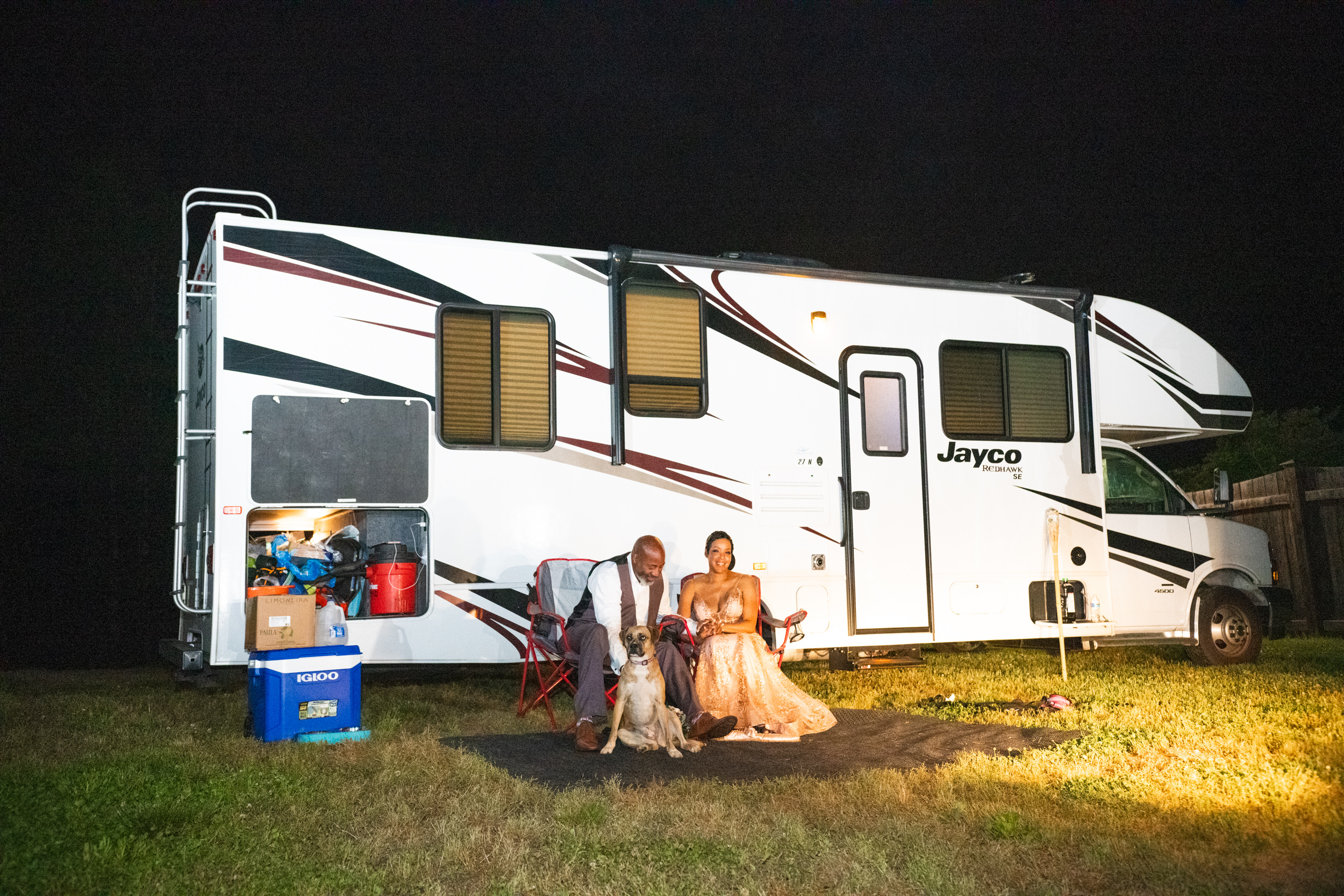 Sonya and Ray with their dog sitting in front of their Jayco Redhawk Class C RV.