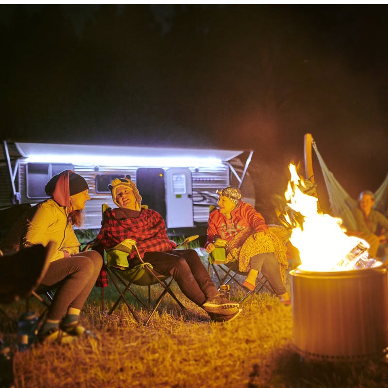 Participants sit by a fire and share stories of their experiences.