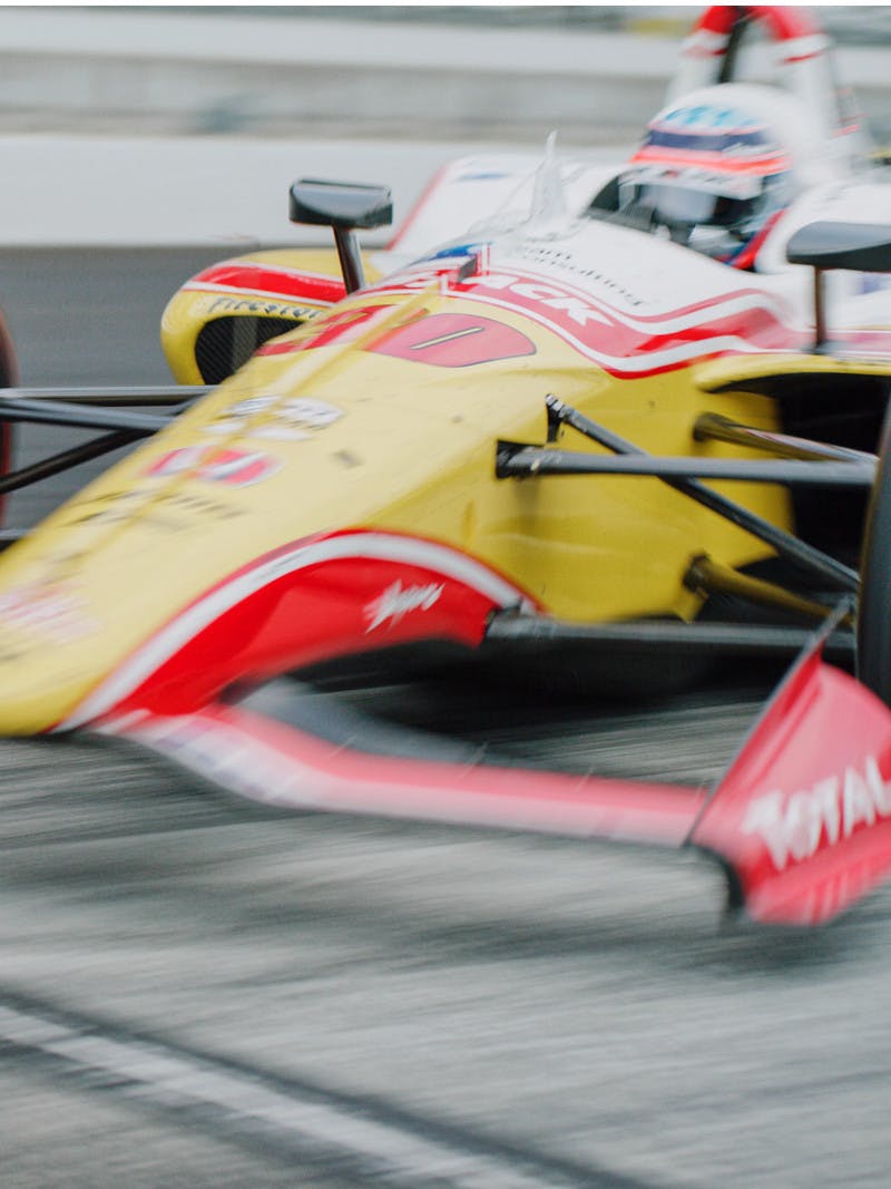 Takuma Sato's race car zooms down the Indy 500 track.