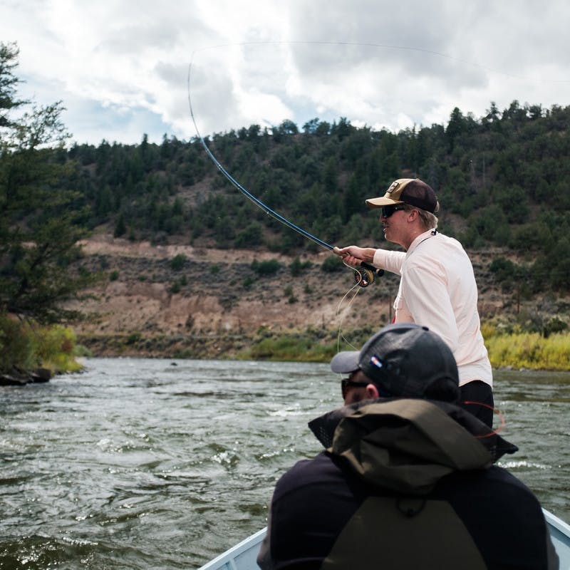 Two men fishing from a canoe. 
