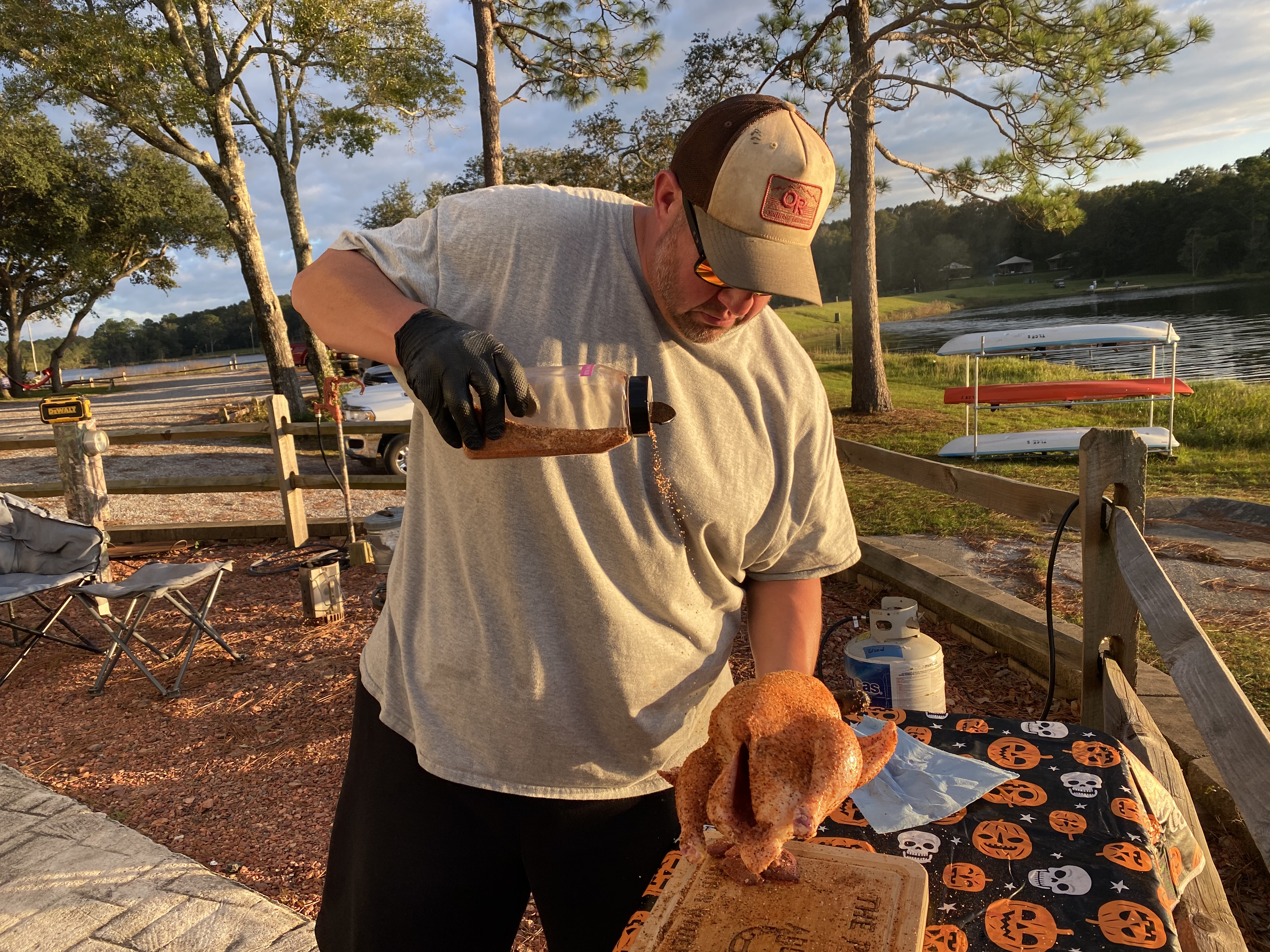 Abby Booth's husband sprinkles on a homemade seasoning blend onto a chicken.