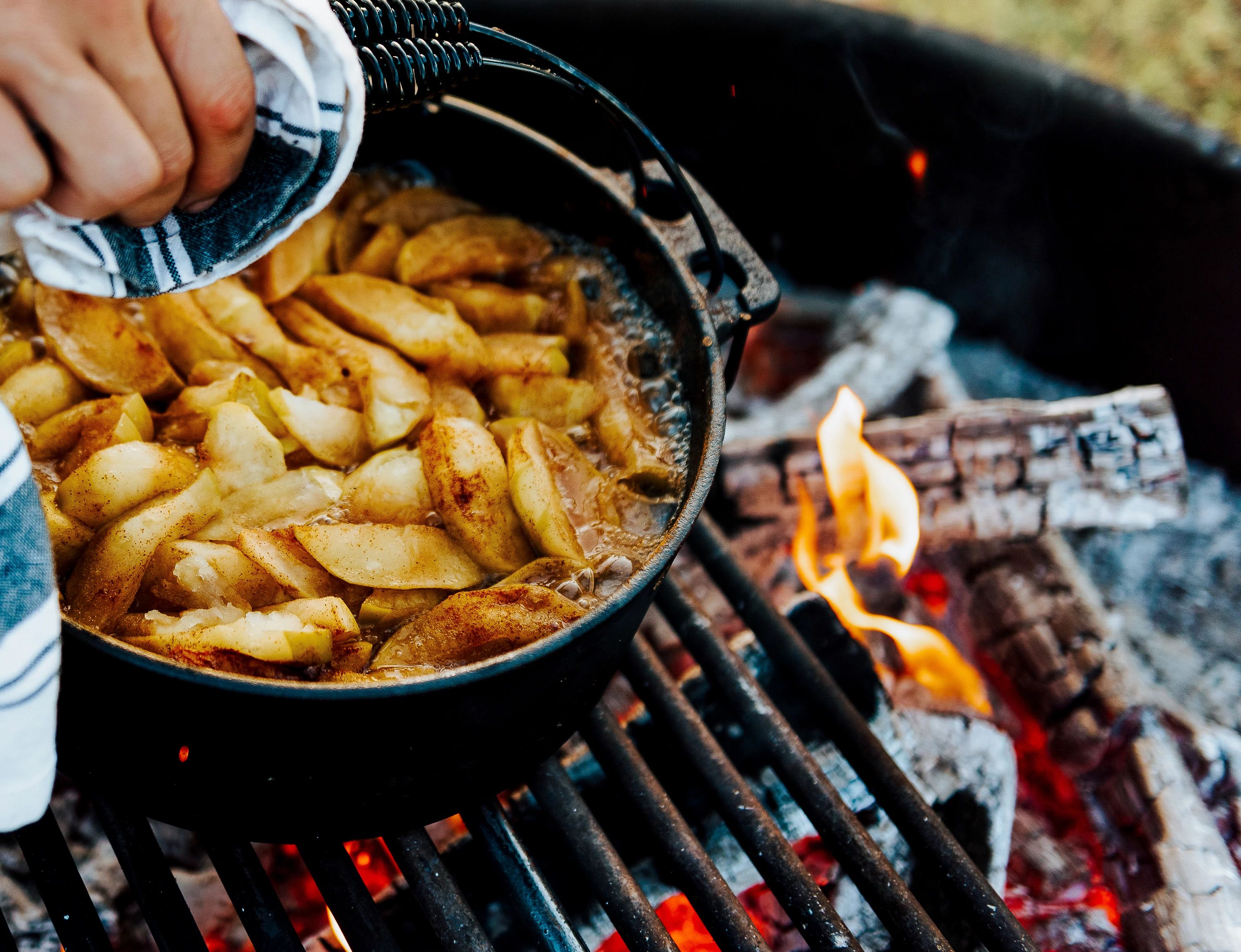 Apples baking in a dutch oven over a fire