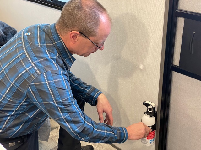 Matt Gleason picking up a fire extinguisher 