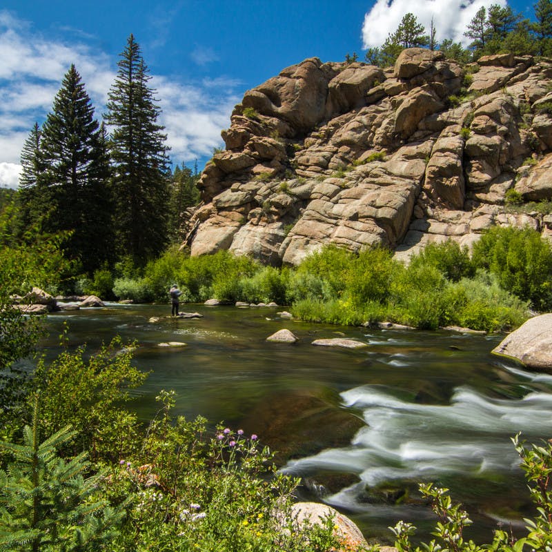 Smooth river waters turning into mild rapids among a rocky terrain.