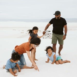 Jane and Willie Register, with their three kids, play in the sand at White Sands National Park in New Mexico.