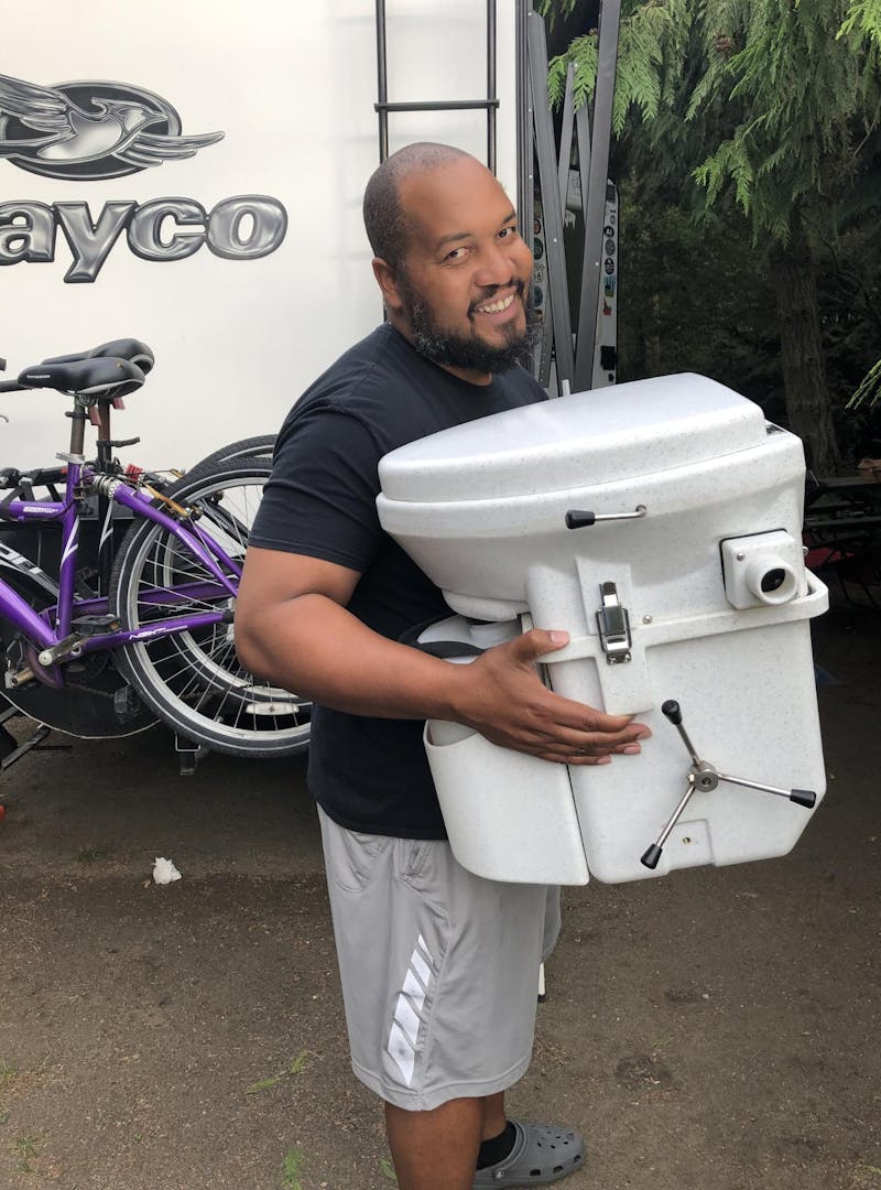 Ben McMillan holding a composting toilet for his Jayco Jay Feather.