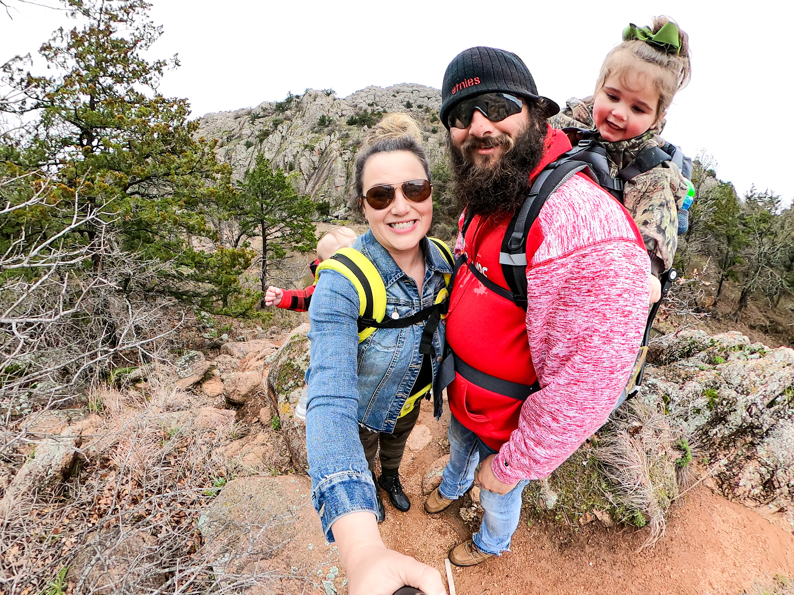 Sammy Seles takes a selfie photo of her husband and two small children on a hike.
