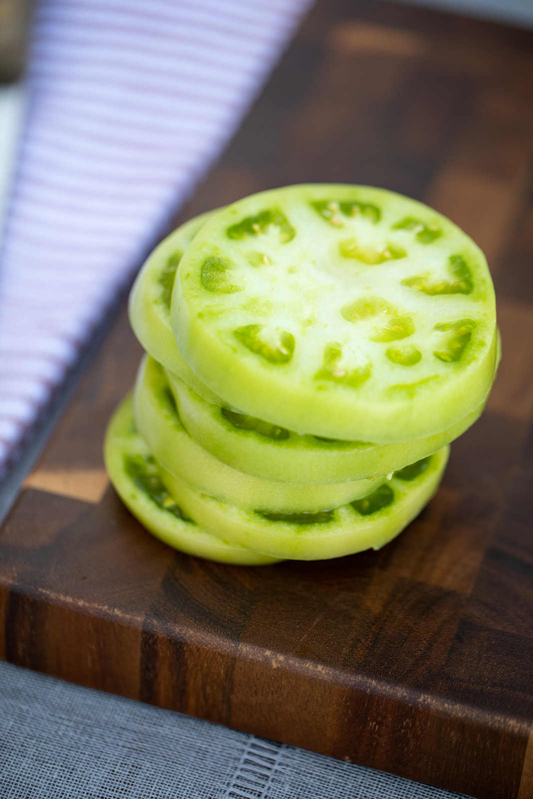Sliced green tomatoes stacked one one another. 