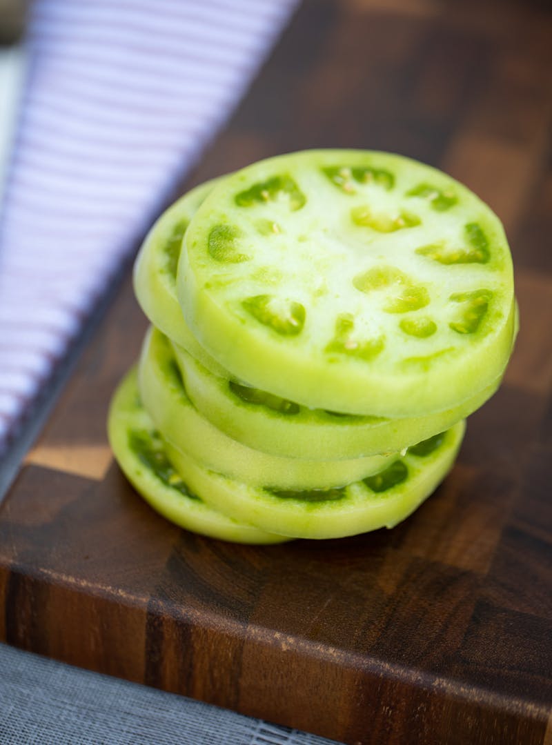 Sliced green tomatoes stacked one one another.
