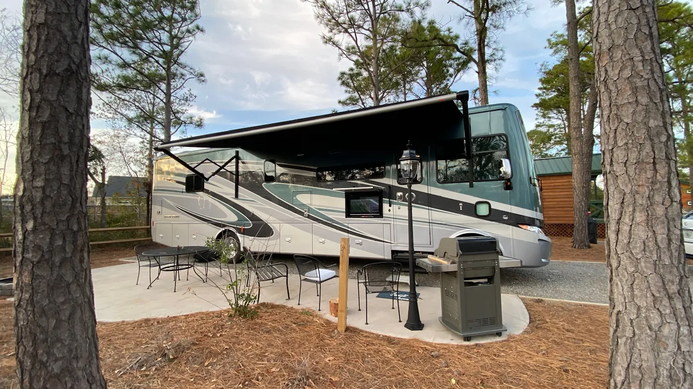 Micheal and Tiffany Dunagan's RV at a campsite with a grill to cook outdoors