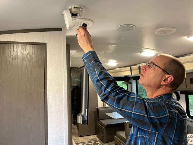 Matt Gleason replacing batteries in a smoke detector