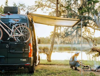 Sarah Glover tending to a fire go cook lobster pie