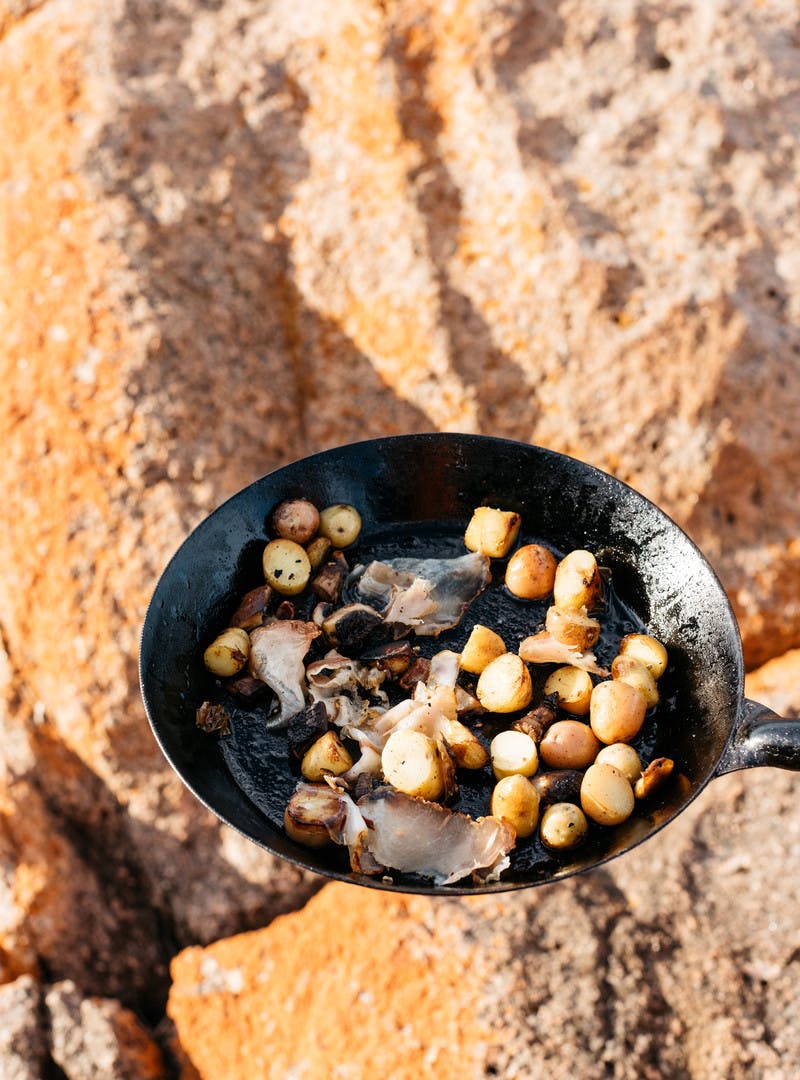 Close up of chopped potatoes in cast iron pan.
