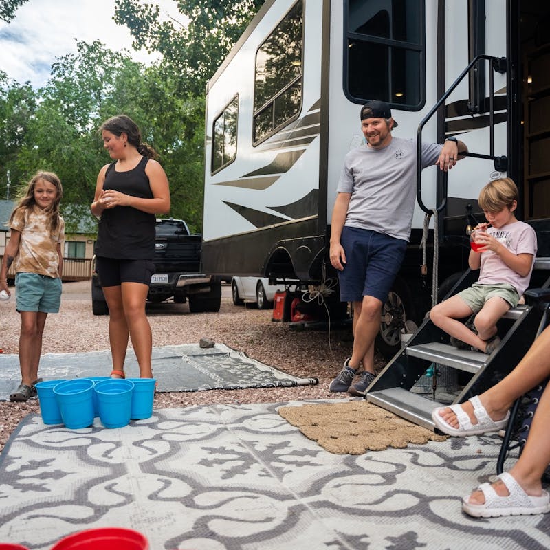 Amanda and Darren Bone playing a game with their kids outside of their RV
