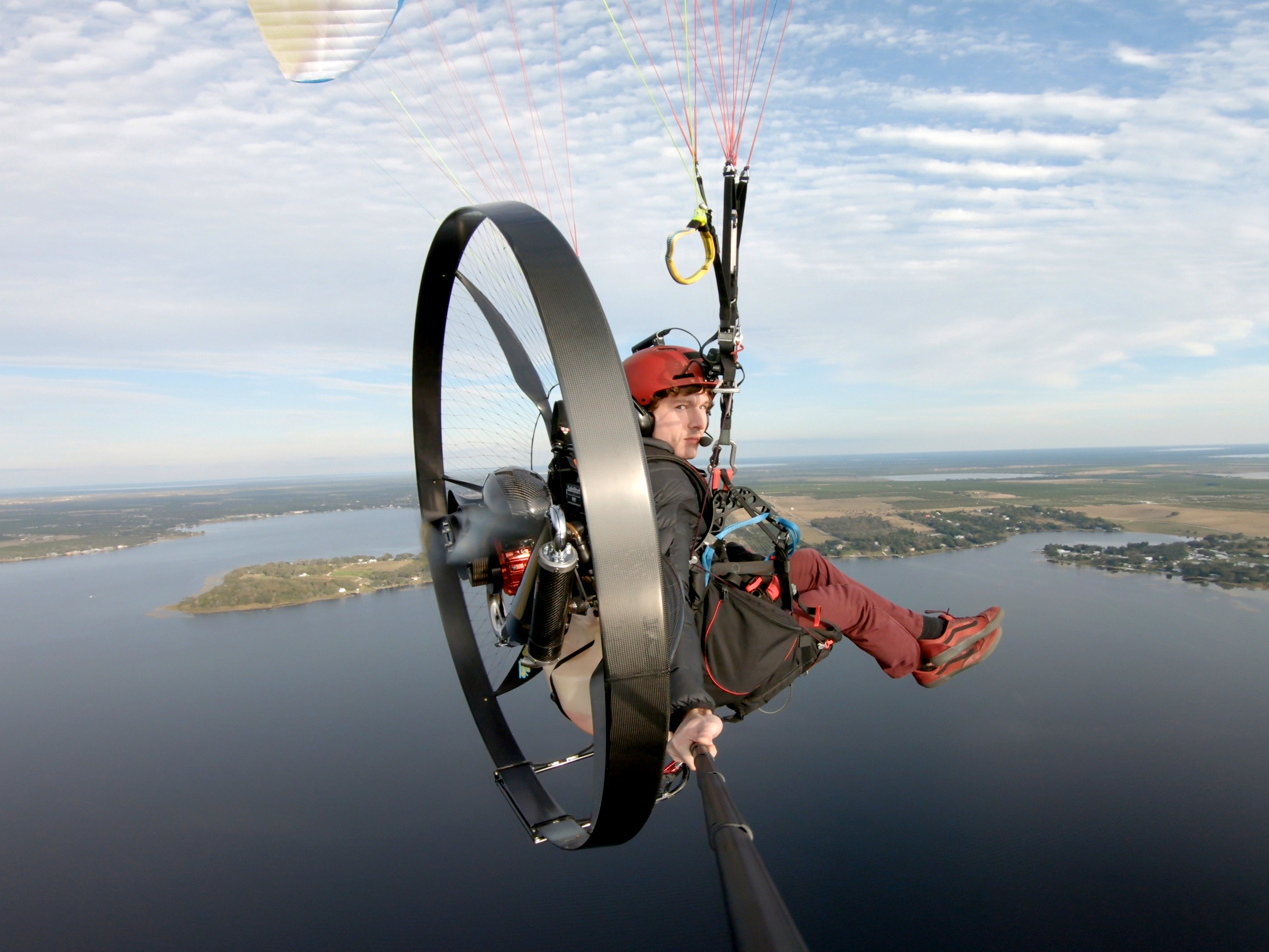Tucker Gott takes a selfie while paramotoring over a lake. 