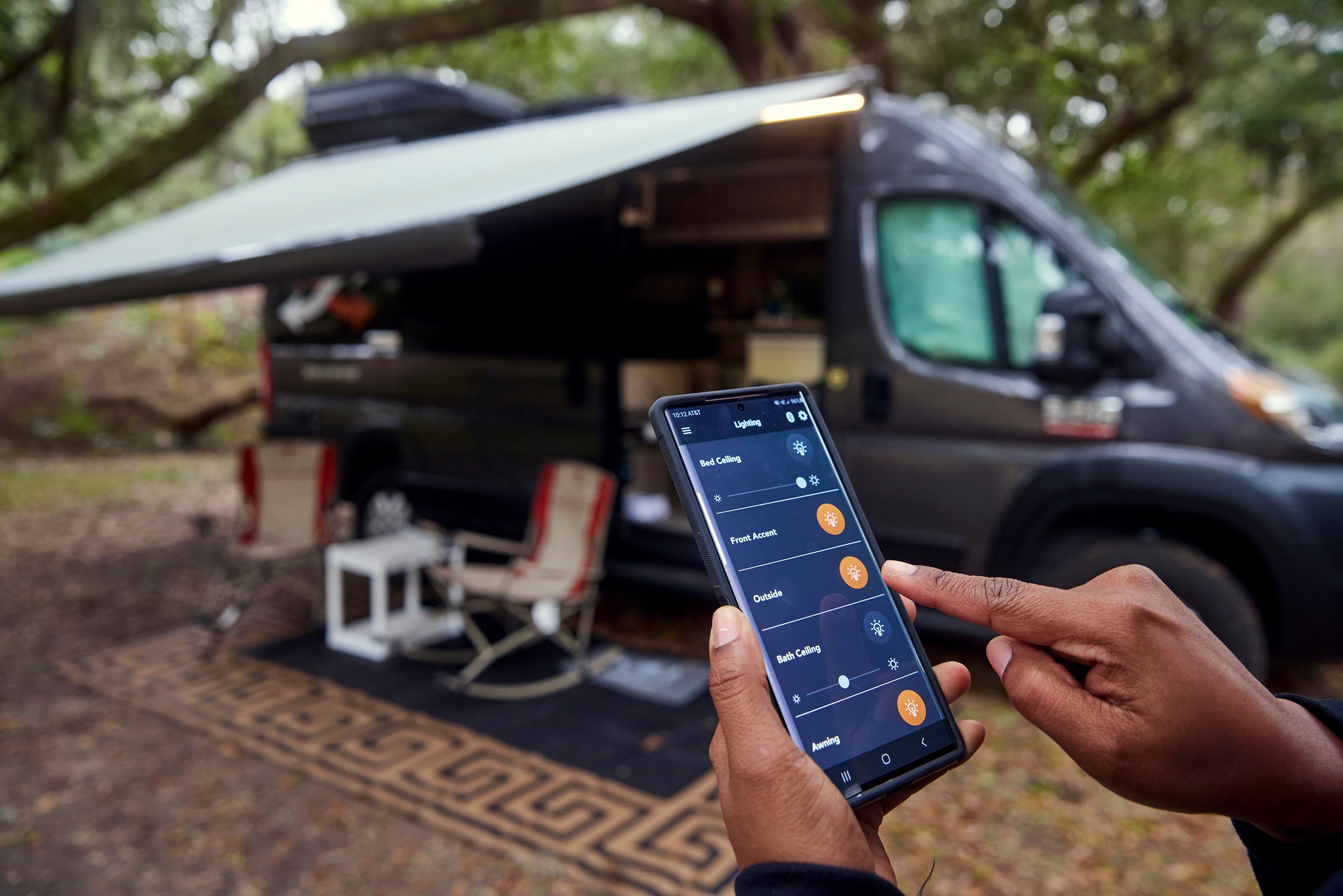 Rocio Rivero holds up an app on her phone that controls the lighting of her Class B RV