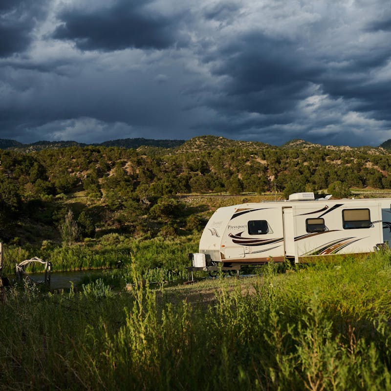 CHRIS HEUBLEIN's Keystone Passport RV parked by a river