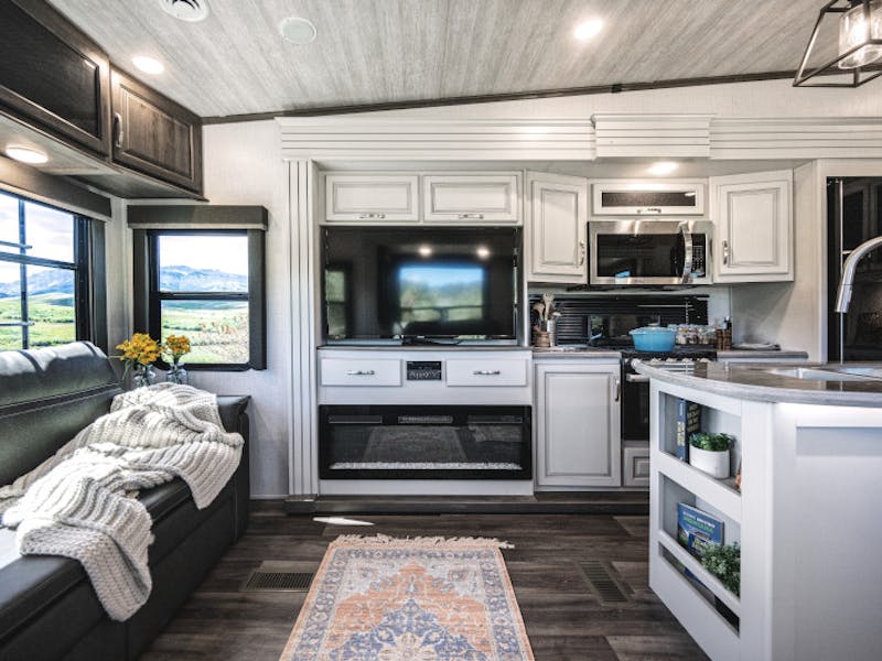 The living room inside a Keystone Cougar featuring an entertainment unit and couch.