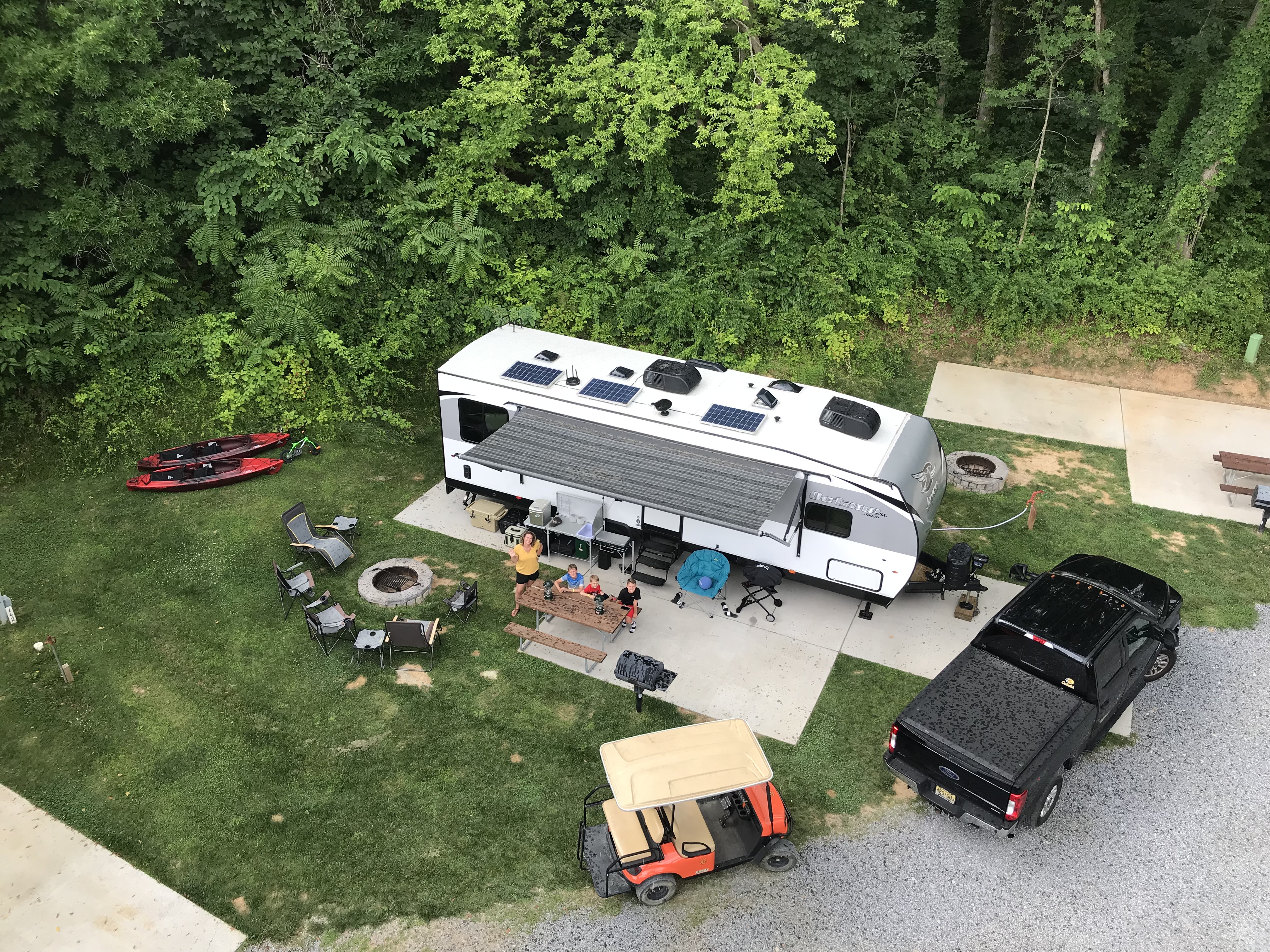 An aerial shot of an RV parked at an idyllic campground. 