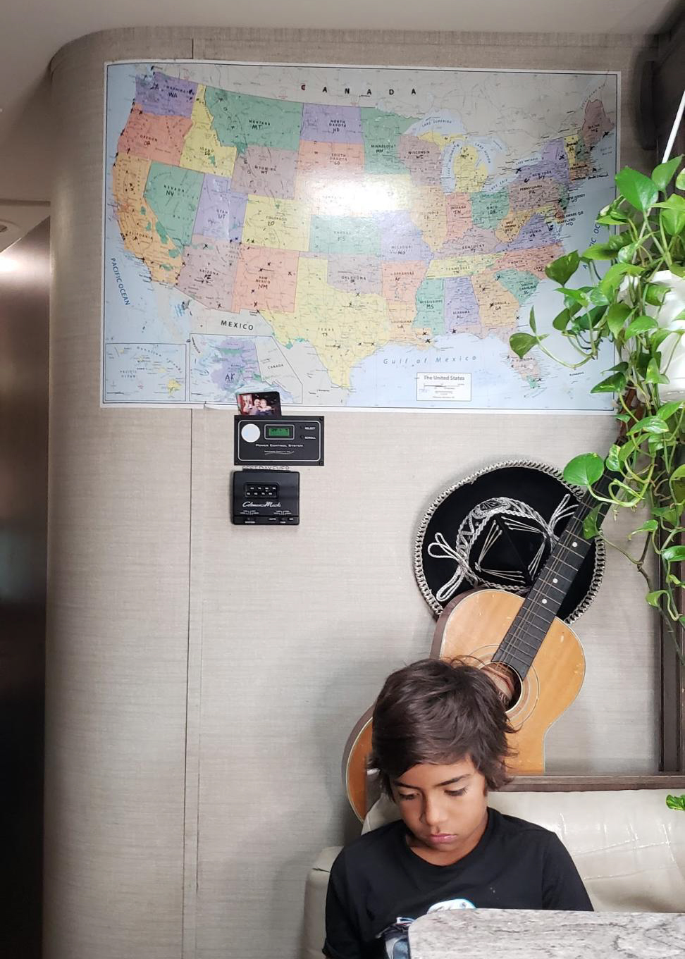 A map hangs on the wall inside of Sandra Peña's Class C RV near the kitchen table where her son sits.