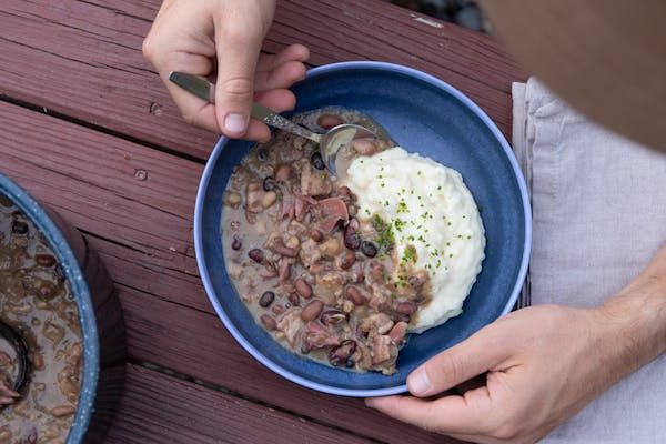 A bowl piled high with mashed potatoes and a medley of mixed beans.