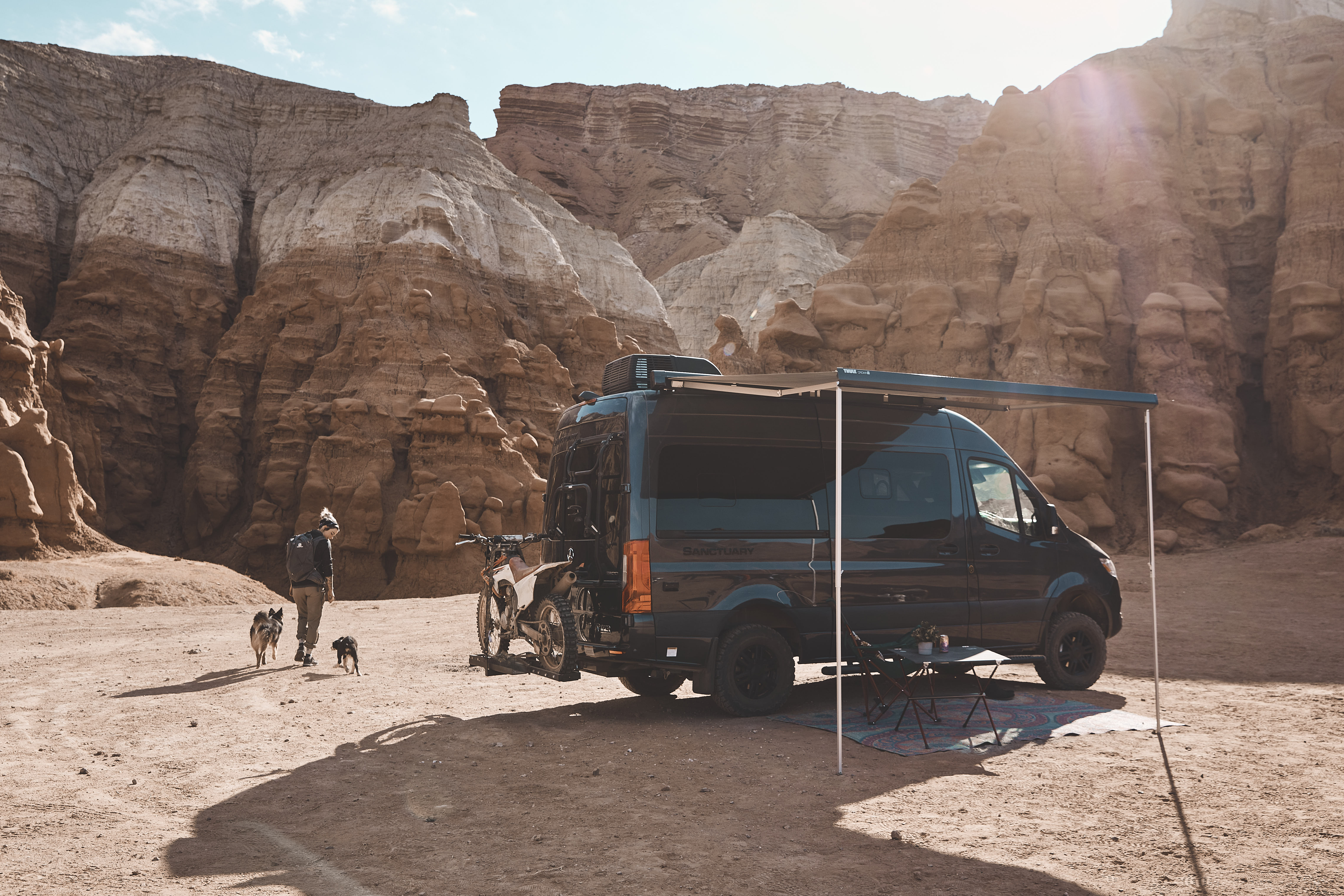 Kalen Thorien and her two dogs walk away from a TMC Sanctuary Class B RV.