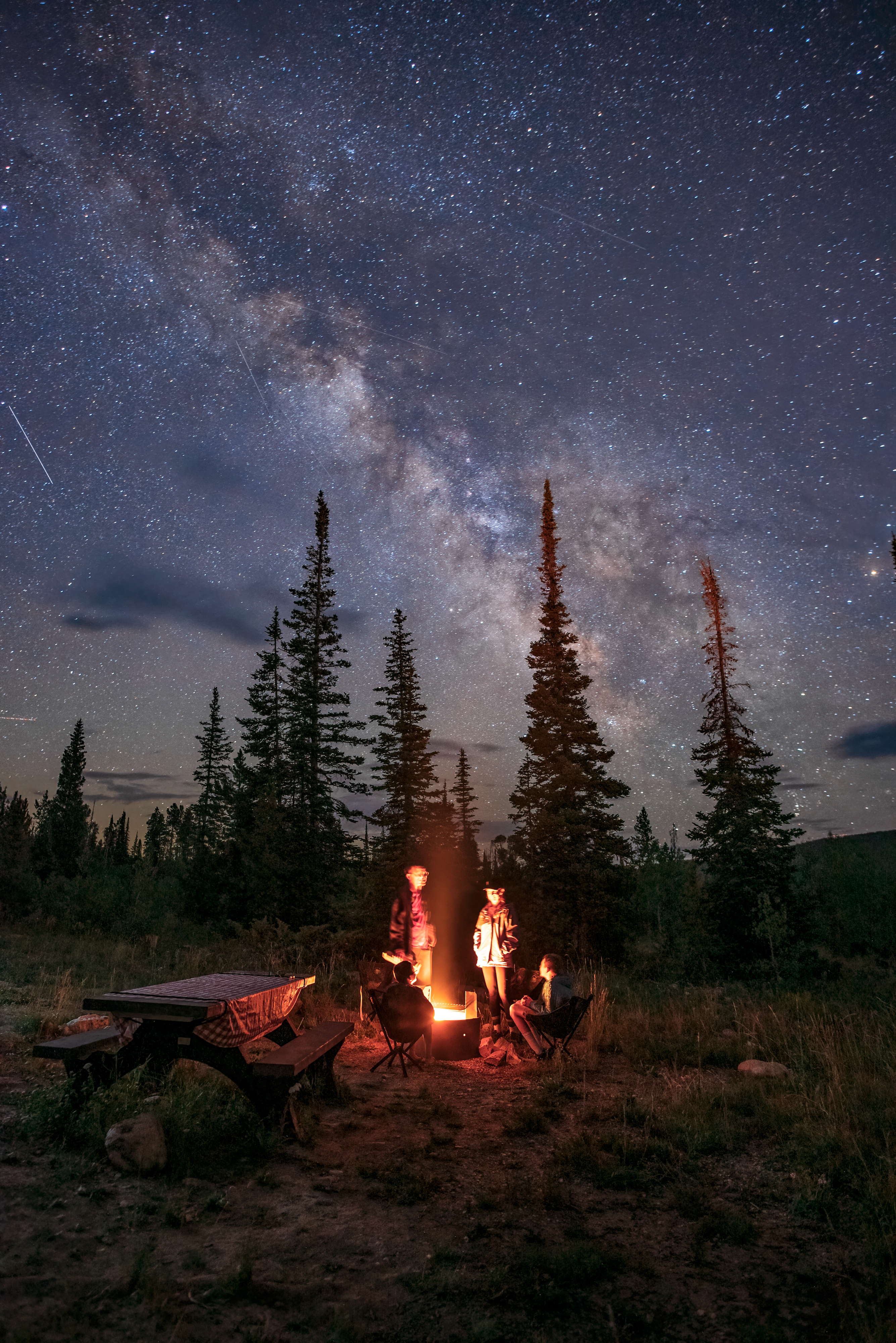The Takacs family around a campfire at Ryan Park Wyoming under the milky way