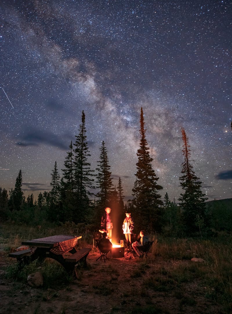 The Takacs family around a campfire at Ryan Park Wyoming under the milky way
