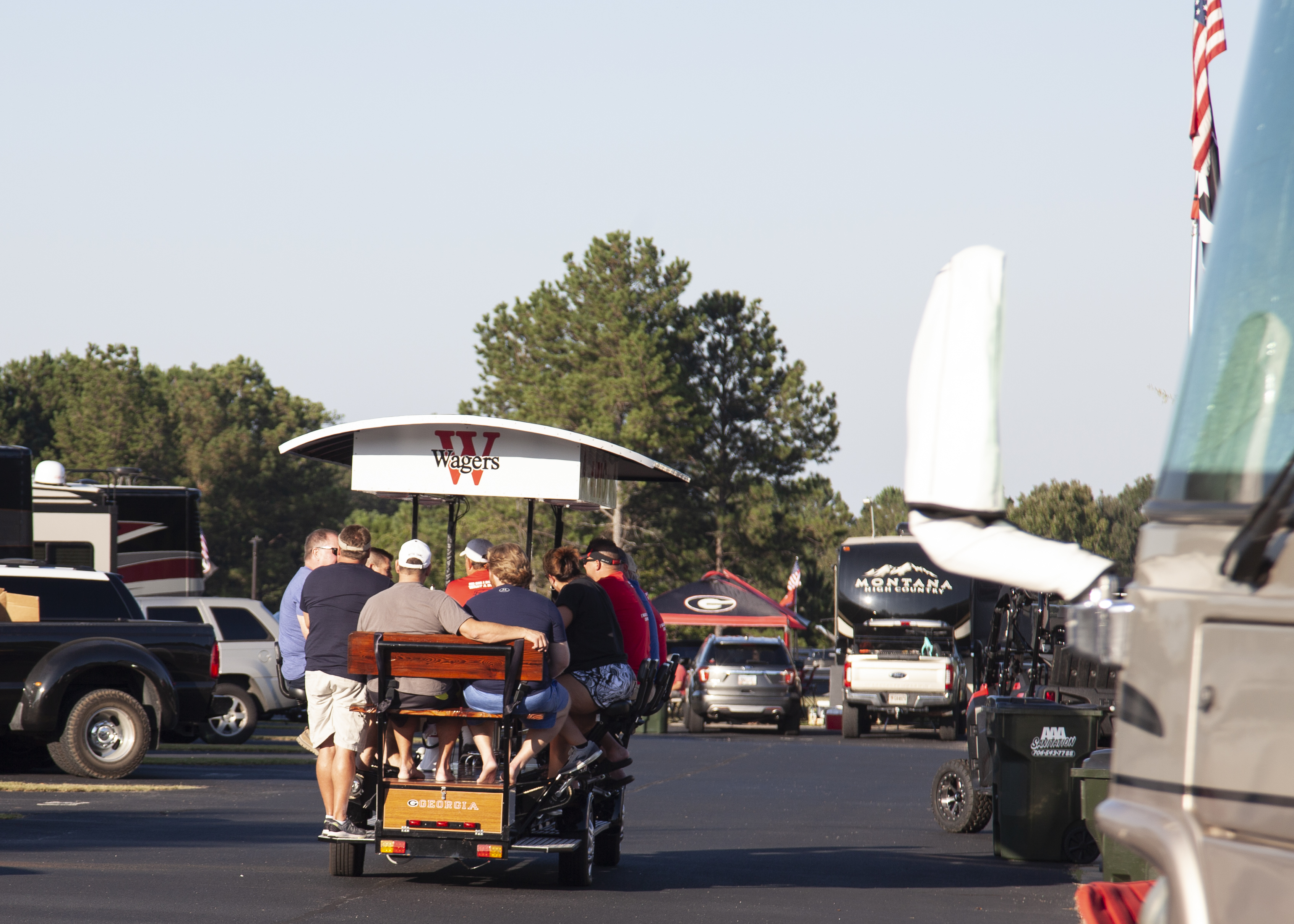 A bunch of people on a bicycle-powered party cart inside the RV park. 