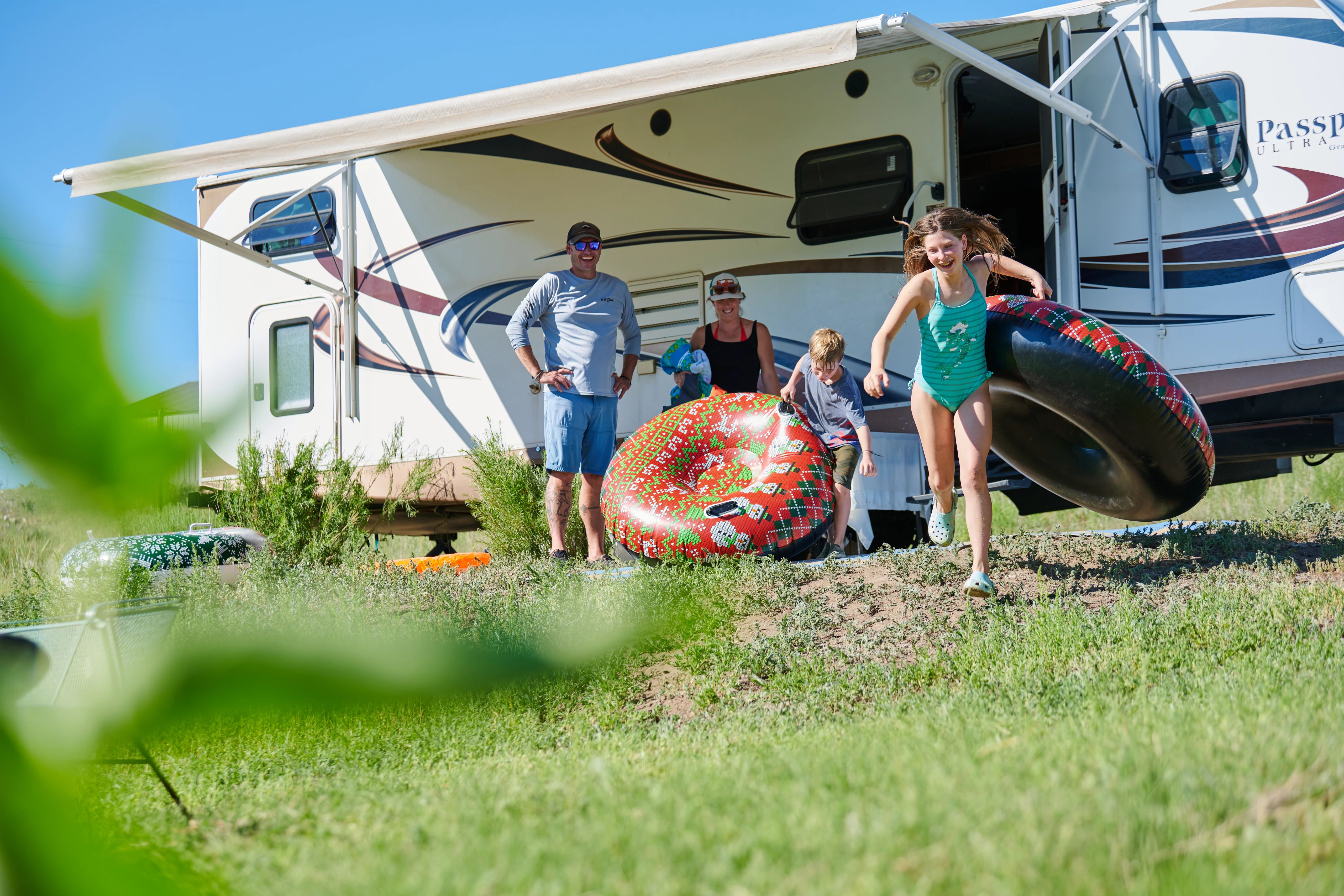 Chris Heublein's kids running towards a river holding floating devices