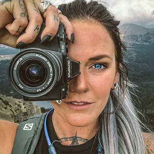 Kalen Thorien holds up her camera to her eye pretending to take a picture while getting her picture taken.