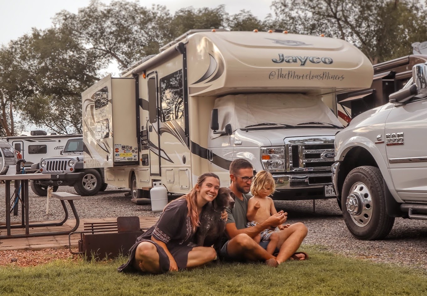 Holly Miner and her family sit at a campground in front of a Jayco Greyhawk