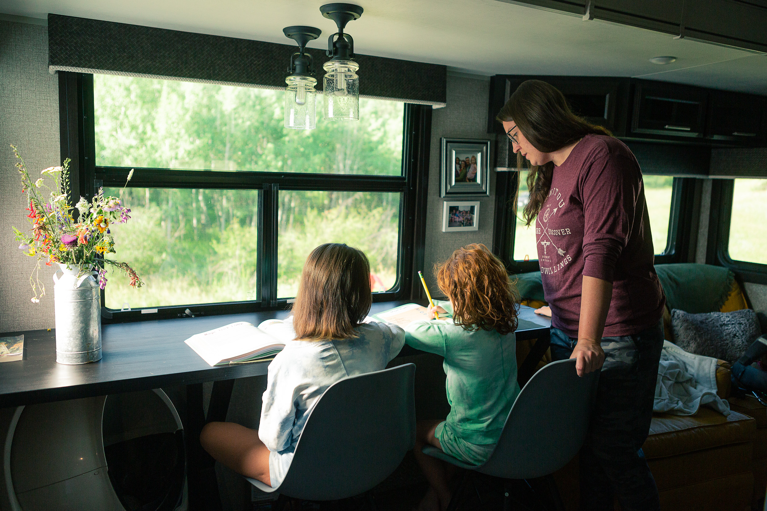 Kate Roberson helping her daughters with their homework inside their RV.