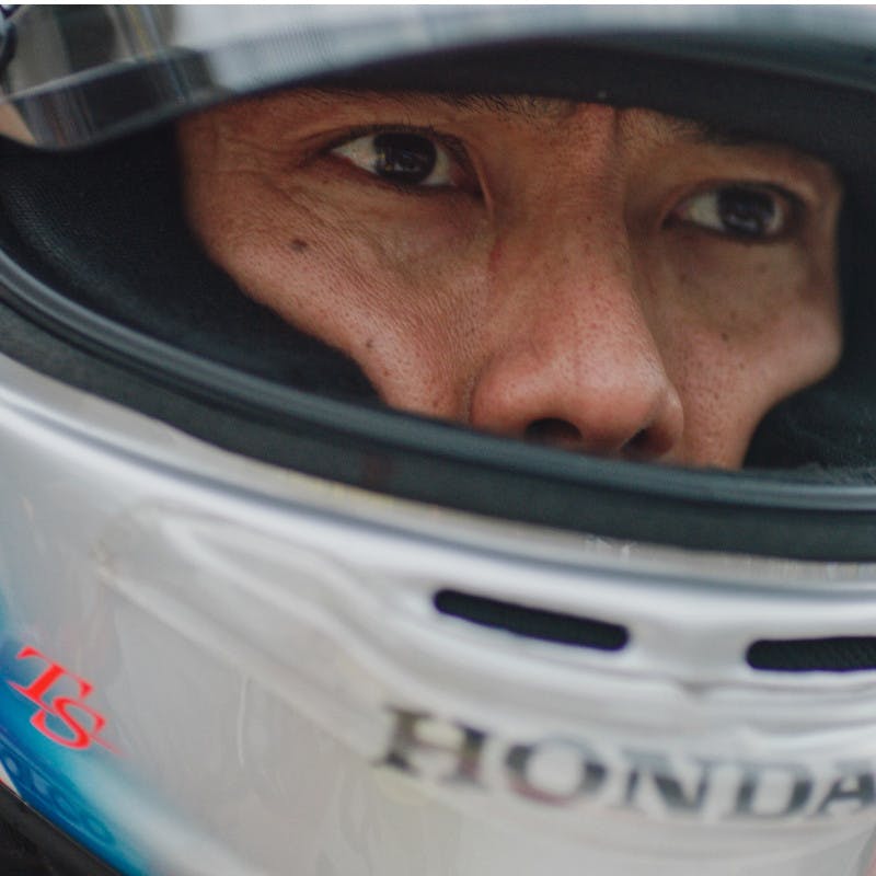 Takuma Sato puts on his helmet before getting into his race car at the 2019 Indy 500.