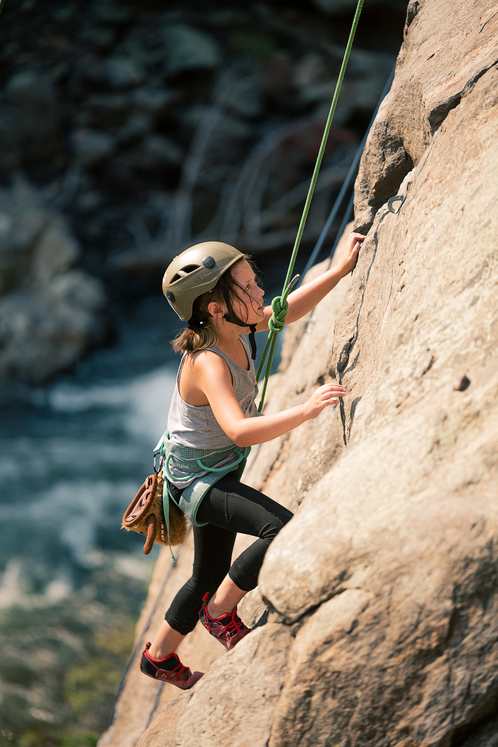 Rosie Roberson climbing up a rockwall. 