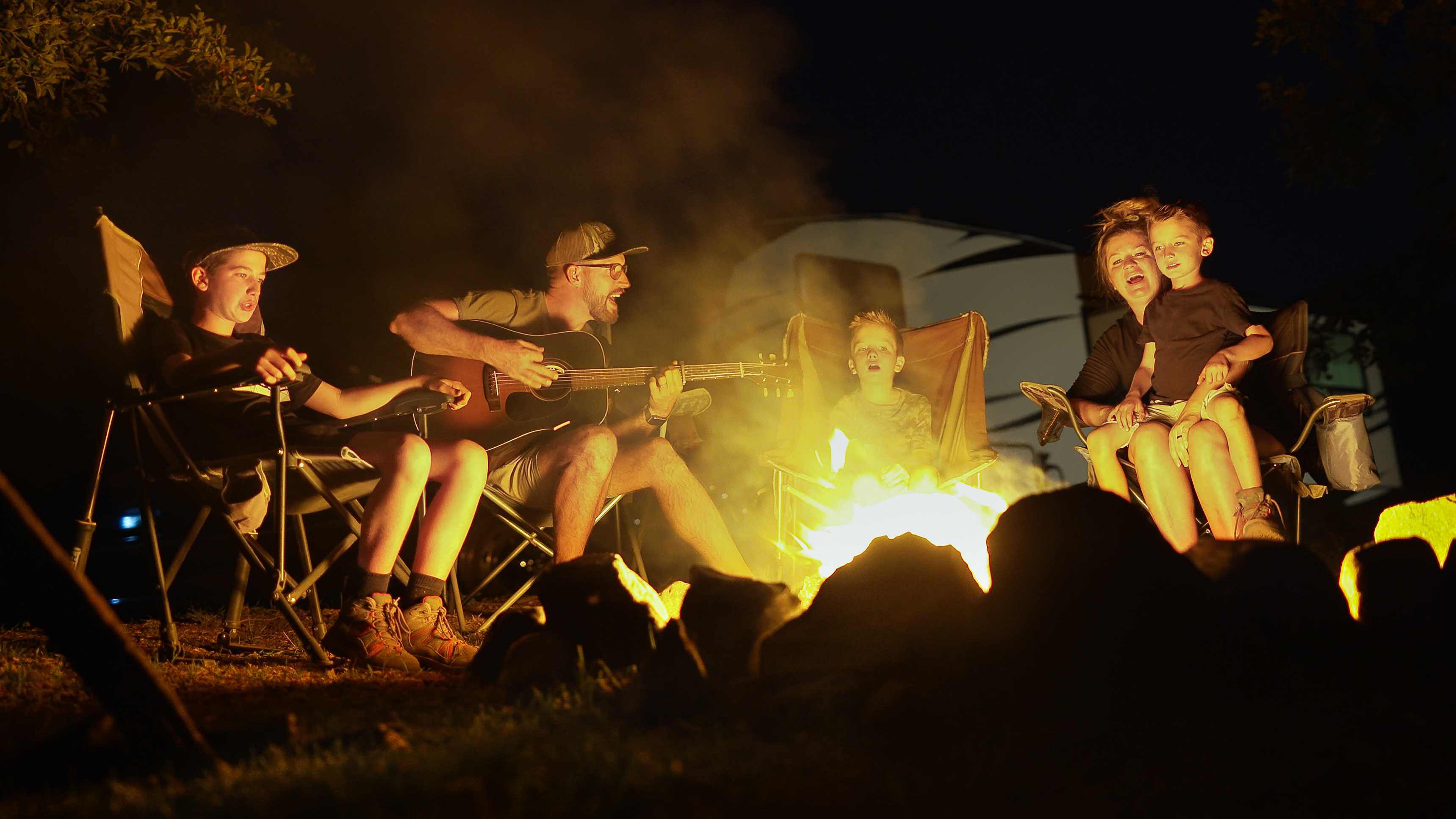 The Cutler family sings around a campfire.