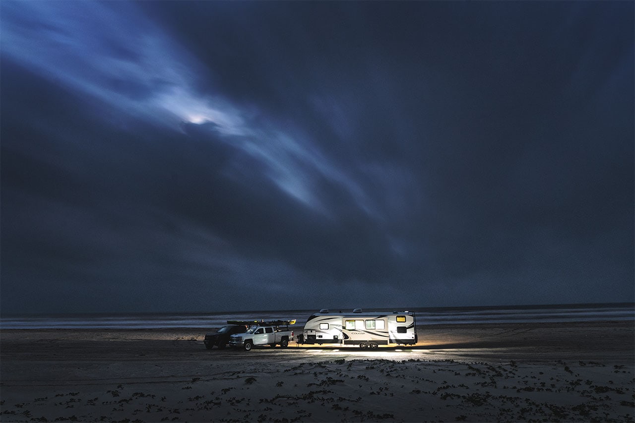 Keystone Cougar fifth wheel on the beach, lip up at night