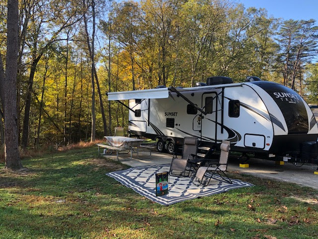 A sunset trail travel trailer parked at a campground. 