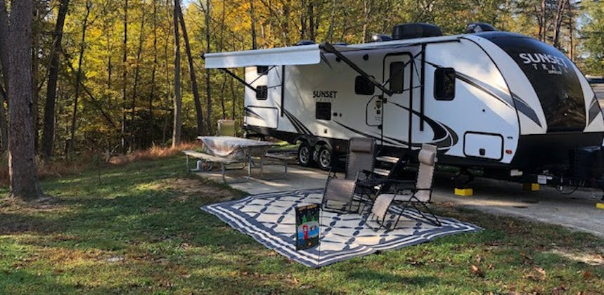 A sunset trail travel trailer parked at a campground.