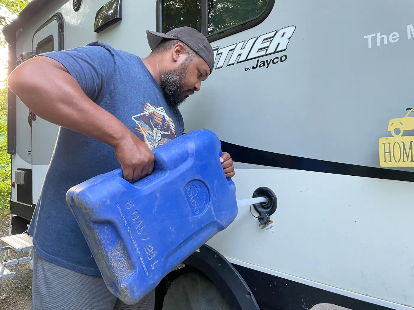 Ben McMillan adding to the freshwater tank from a portable water jug
