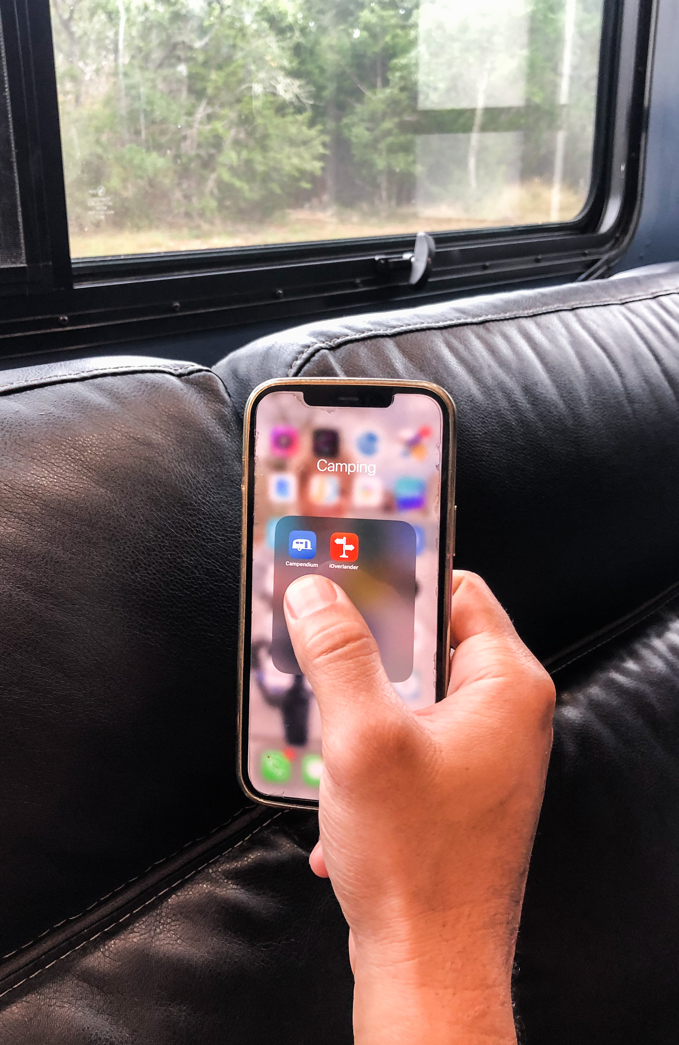 BLAKE EDMUNDS holding up his phone with camping apps on the screen