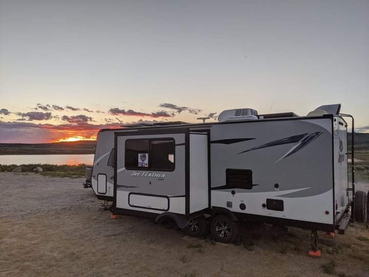 Ben and Christina McMillan's RV boondocking next to a lake at sunset