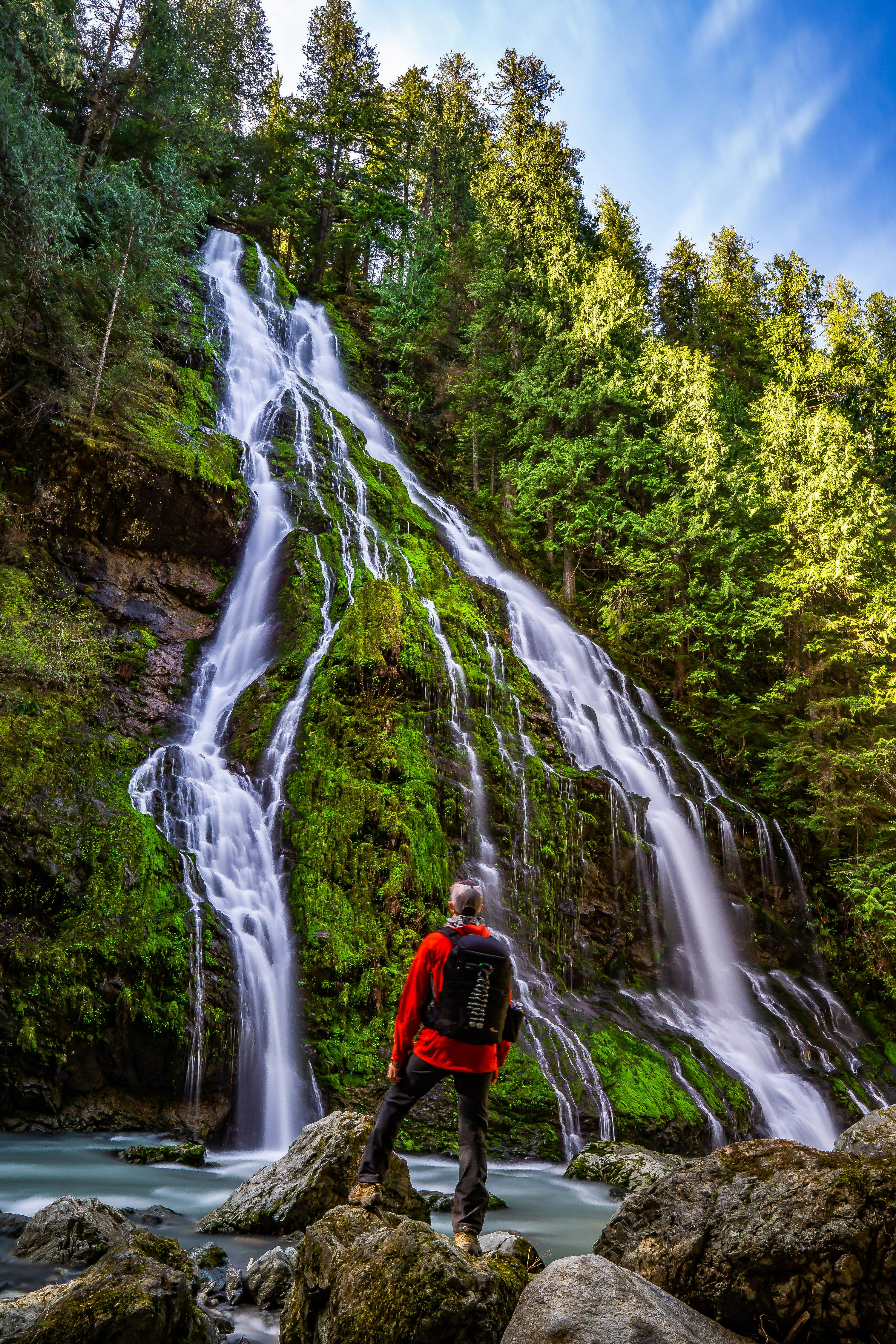 A man looking at a waterfall in Mt. Baker National Forest