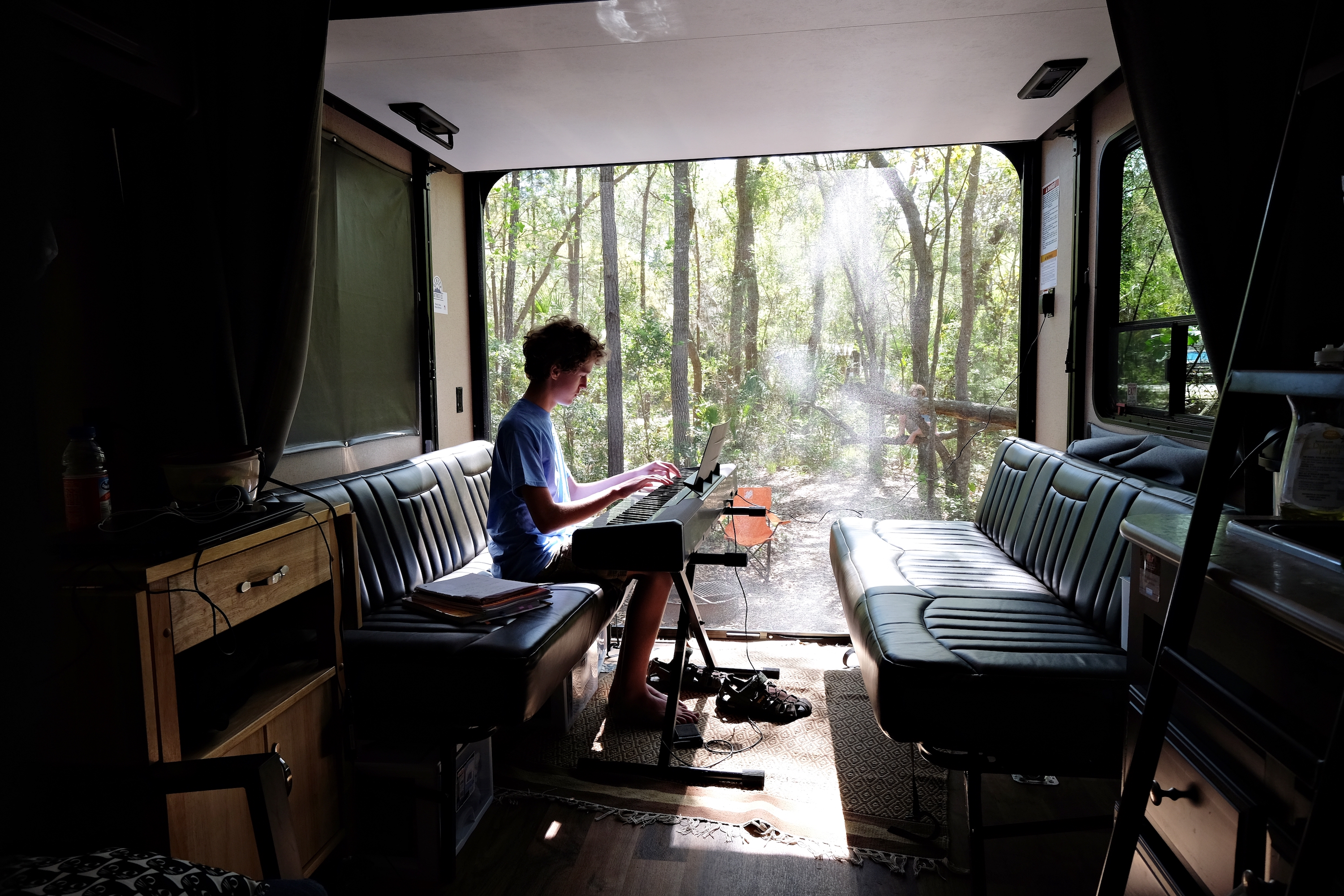 Gretchen Holcomb's son plays a keyboard in the garage of their Jayco Octane Toy Hauler. 
