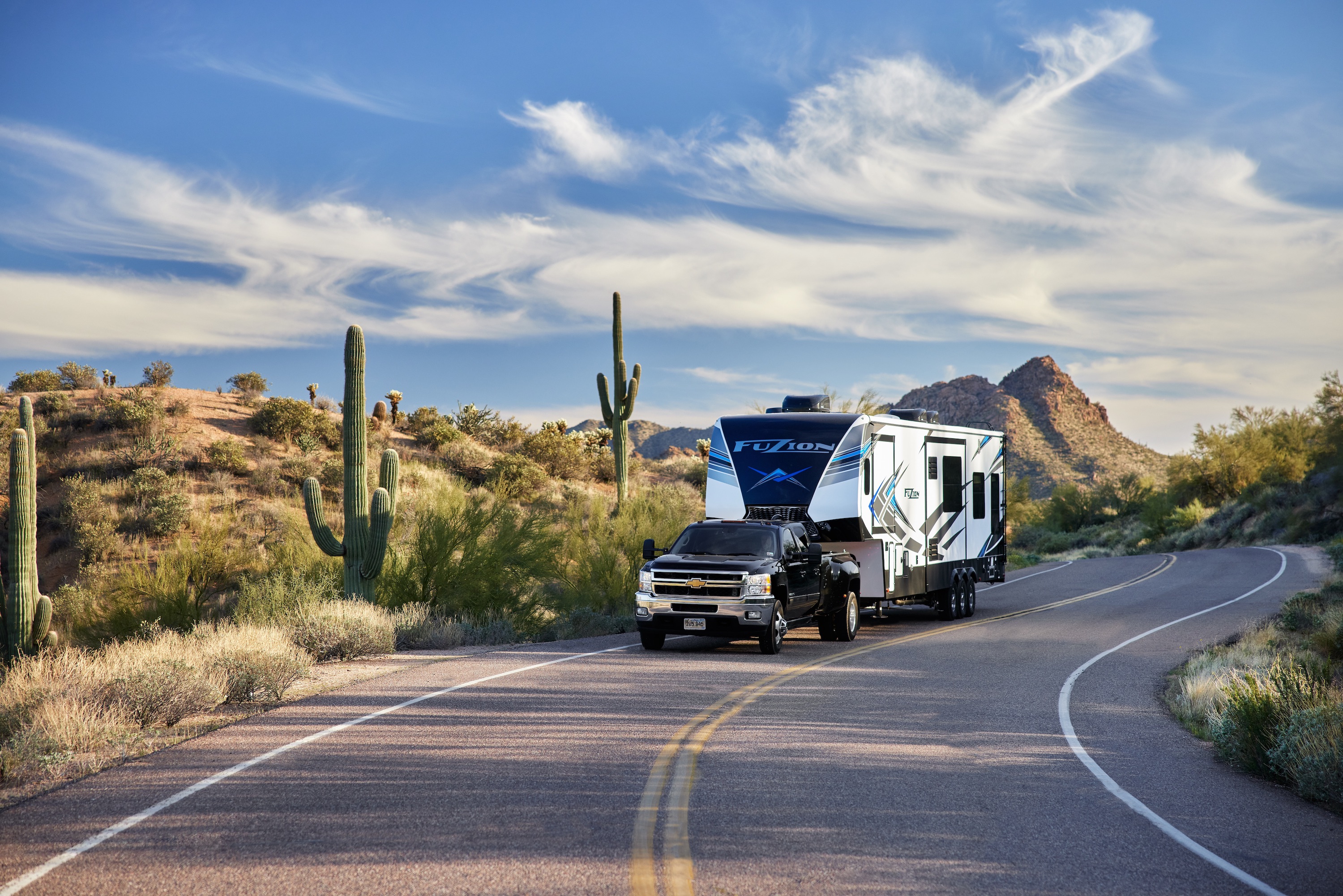 Robin and Warren towing their Keystone Fuzion on a windy desert road. 