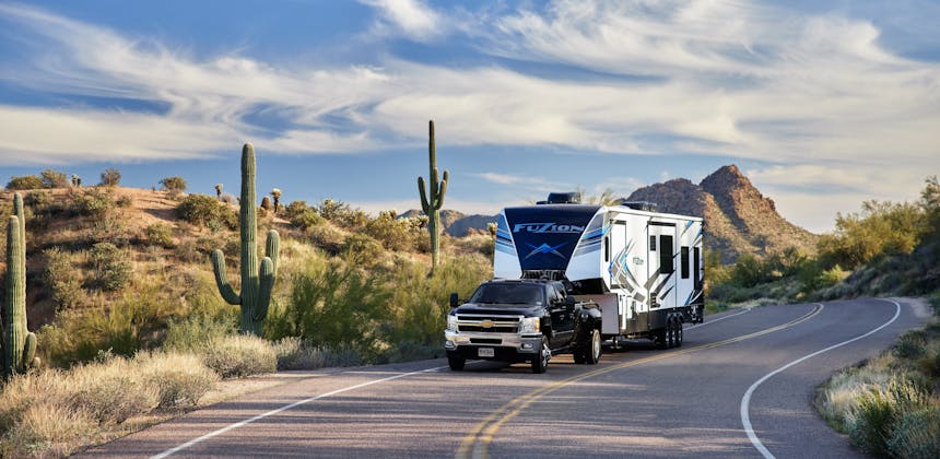 Robin and Warren towing their Keystone Fuzion on a windy desert road.