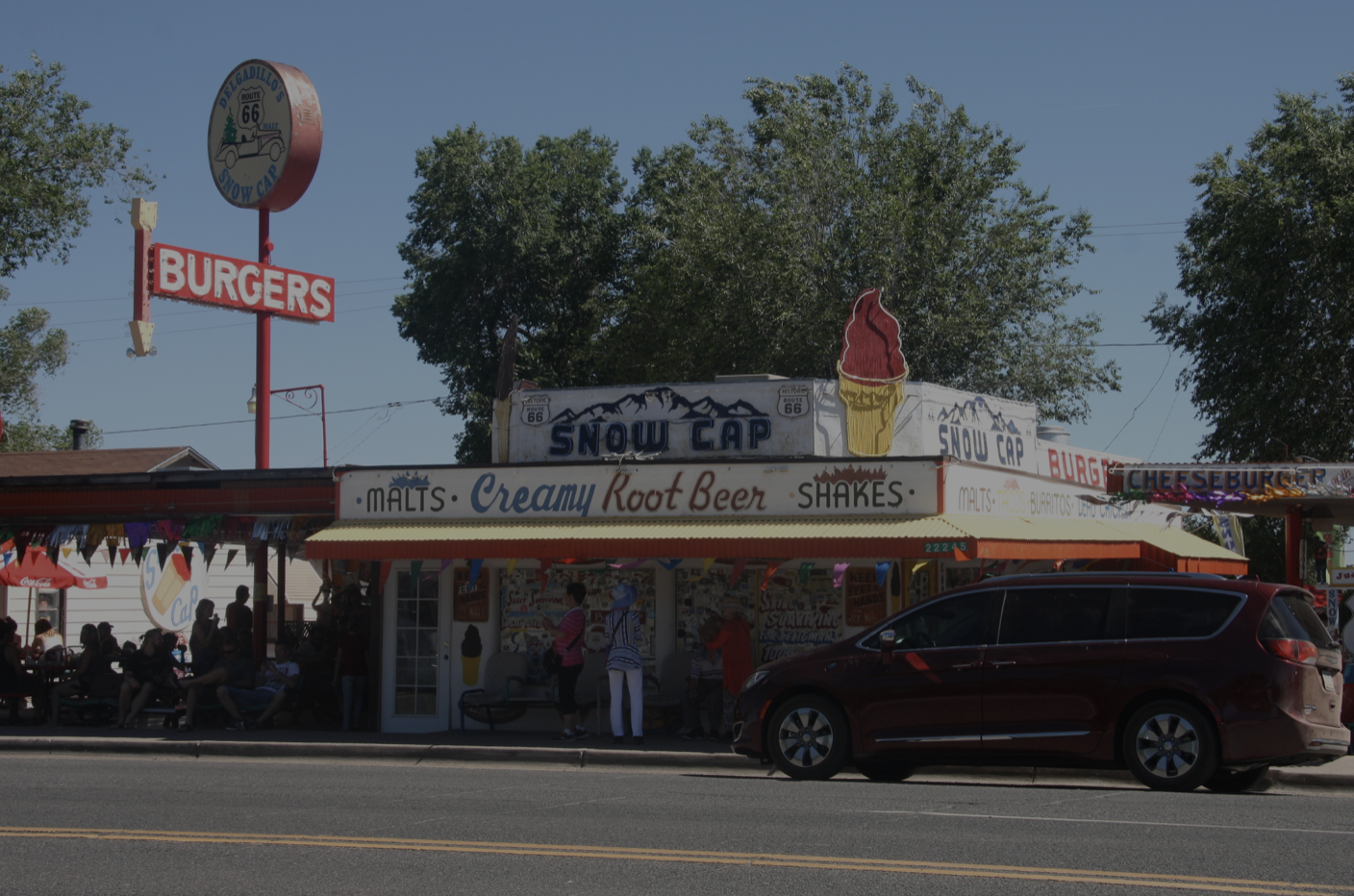 Delgadillos Snow Cap Drive-In restaurant with red van in front 