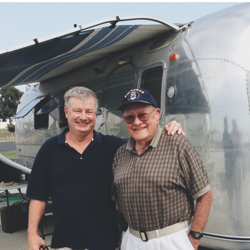 Billy and Grandpa Al standing in front of Airstream travel trailer. 